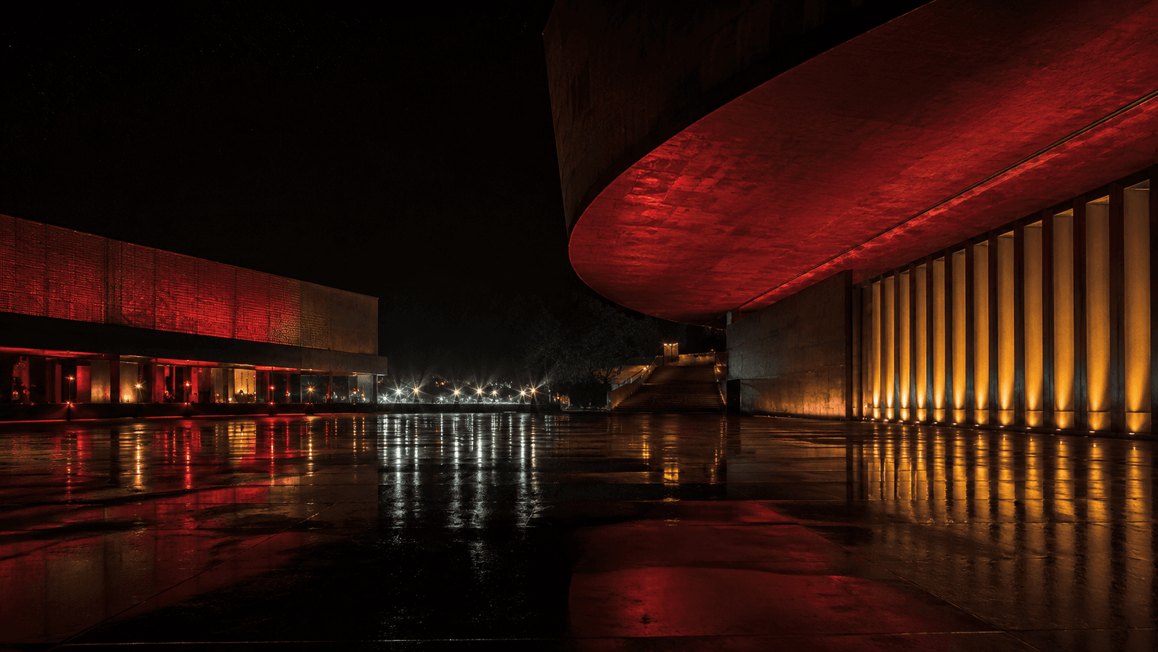 Plaza de un festival cinematográfico iluminada de noche tras la lluvia